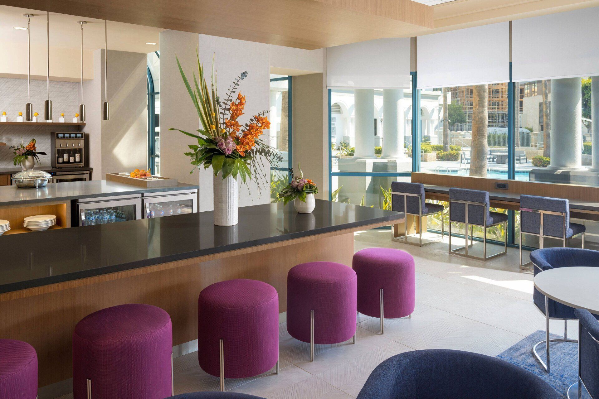 A living room with purple ottomans and chairs