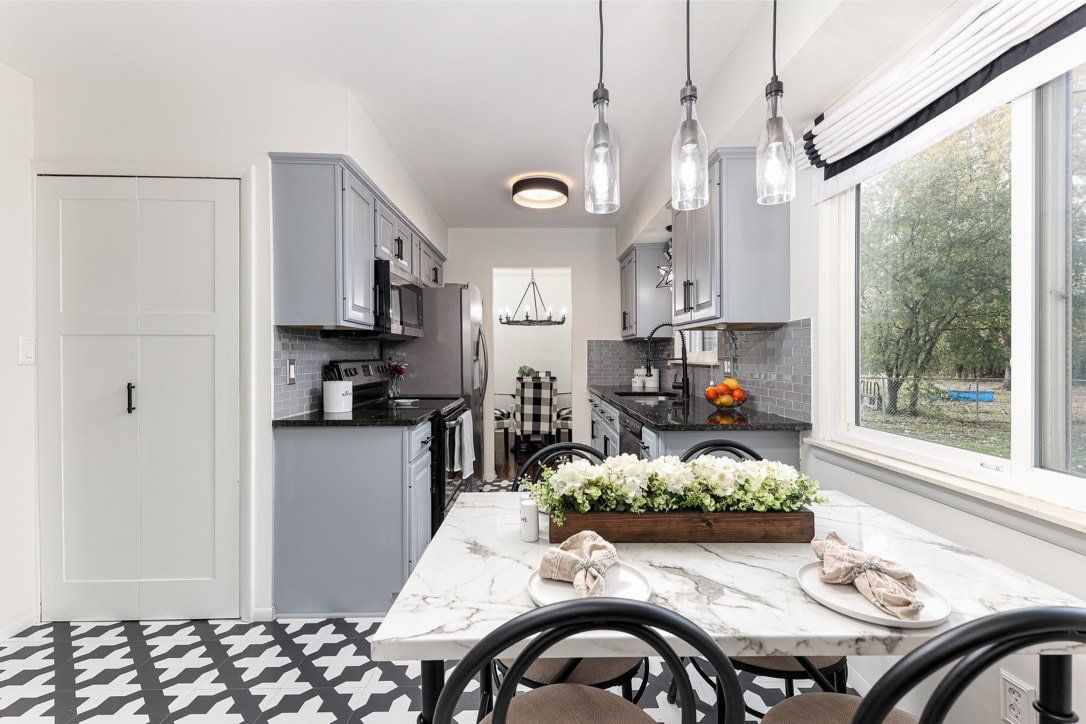 A kitchen with a table and chairs and a window.