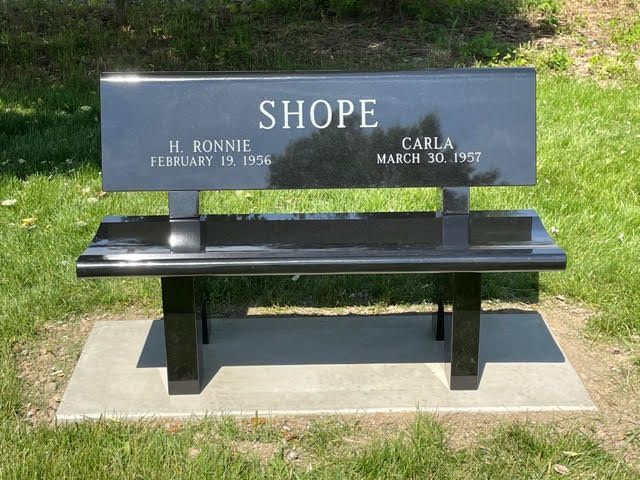 A black bench with the name shope on it