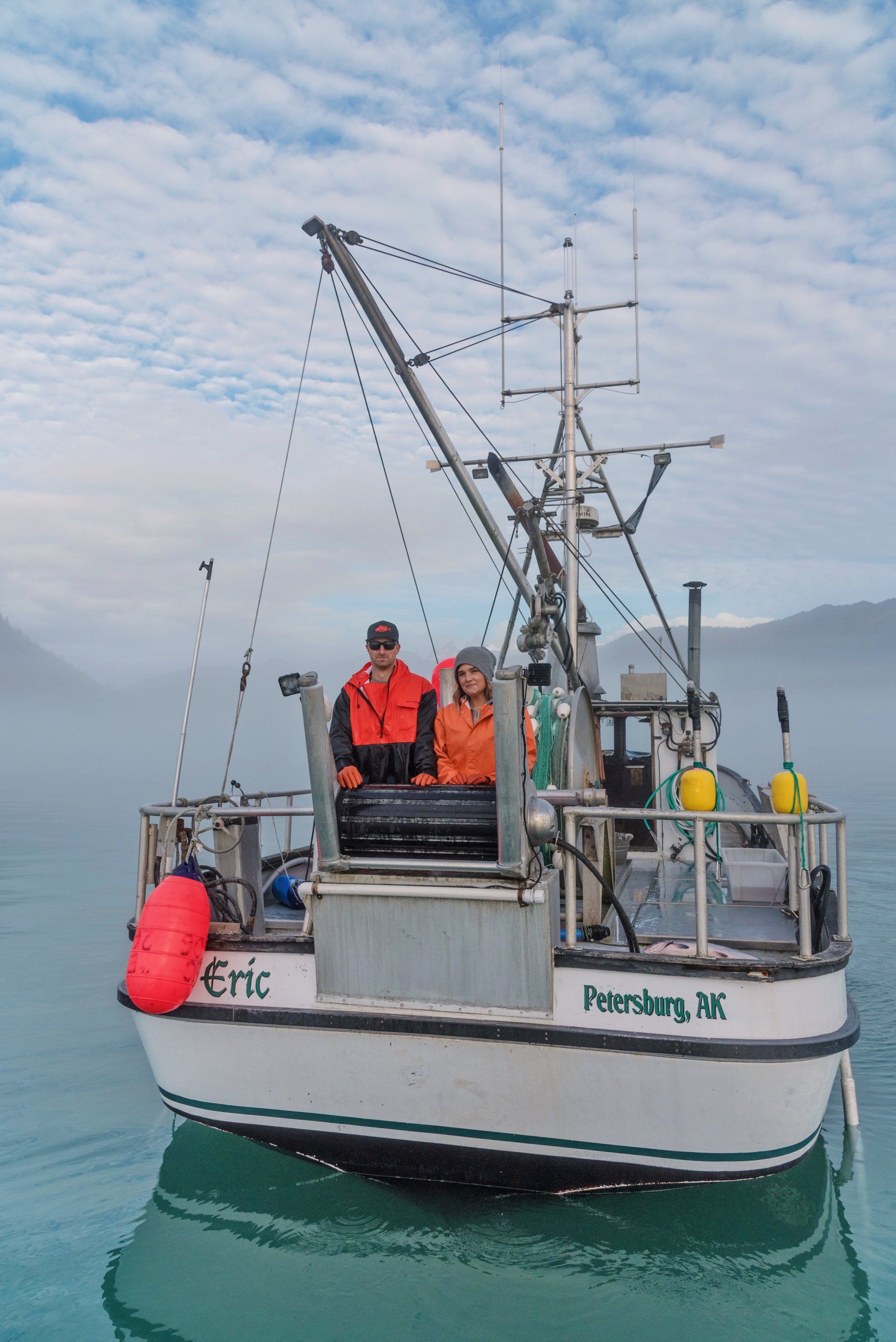 Fisheman catching a fish off the side of s boat
