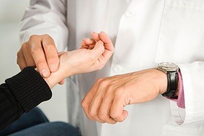 Doctor checking patient's pulse - Diagnostic Services in Gurnee, IL