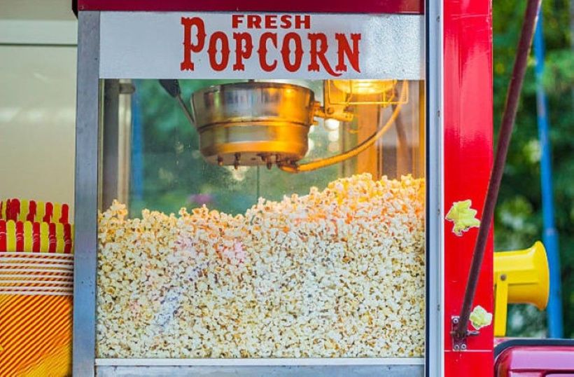 Freshly popped popcorn in a large popcorn machine, ready to be served at a concession stand