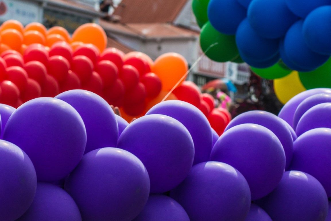 Groups of colorful balloons tied together, adding a festive and joyful atmosphere to the scene.