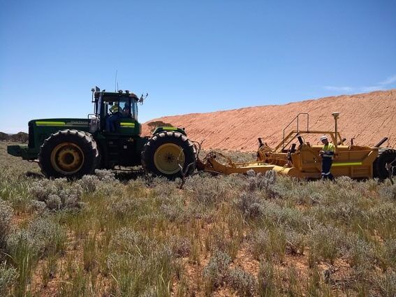 Tractor removing subsoil for a mining project