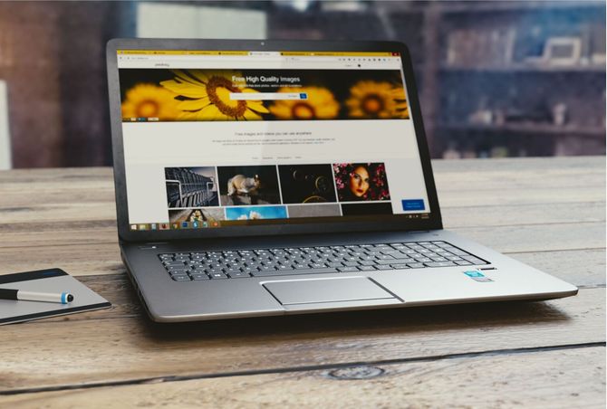 A laptop computer is open to a website on a wooden table.