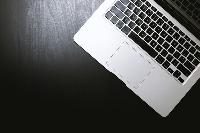 A laptop computer is sitting on a black table.