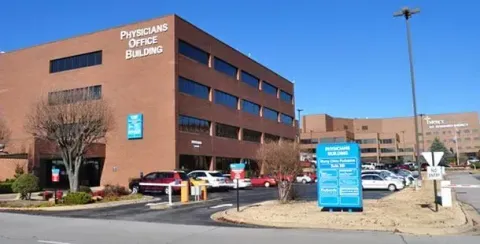 A large brick building with a parking lot in front of it.