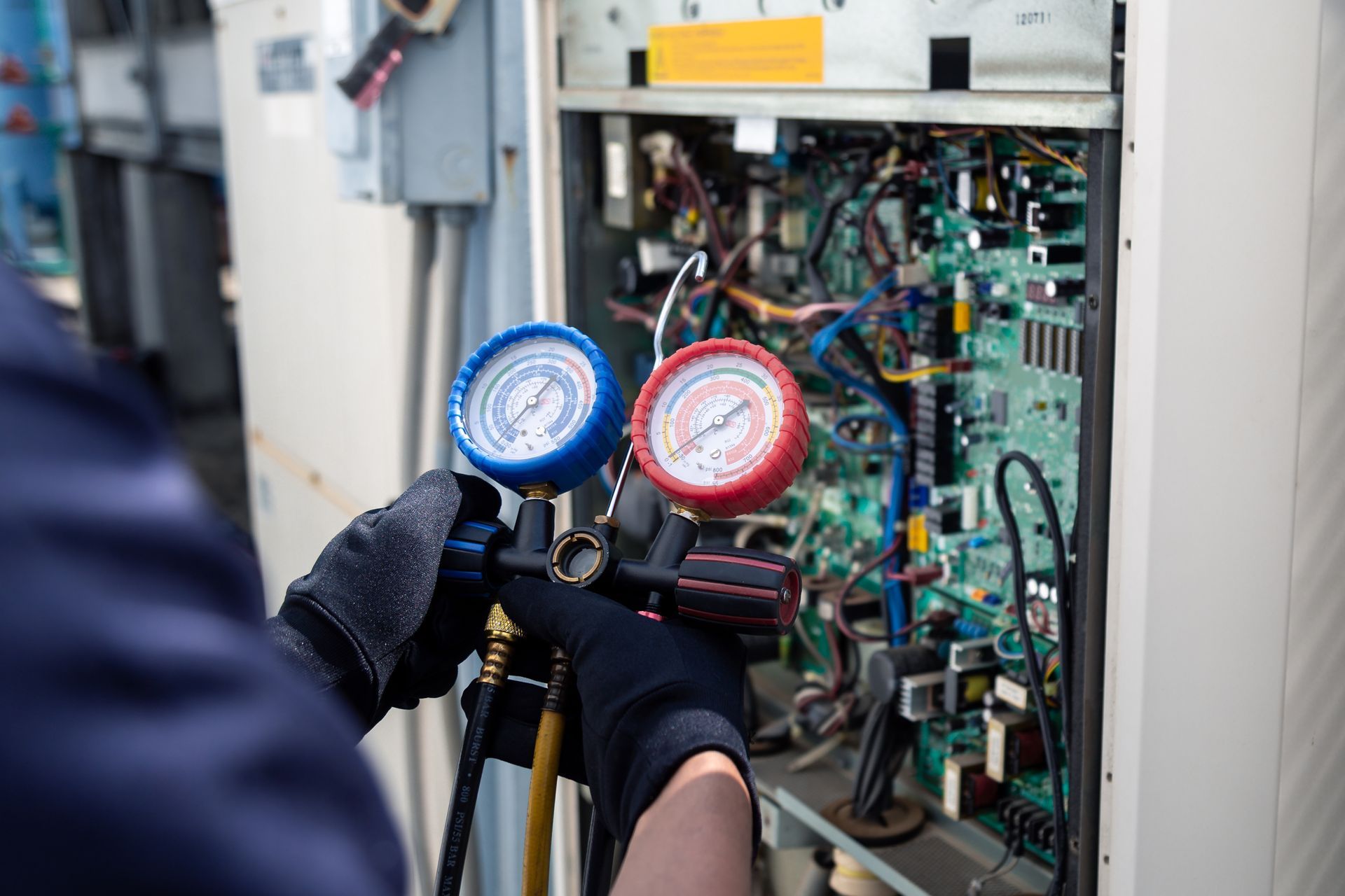 A person is working on a machine with two gauges on it.