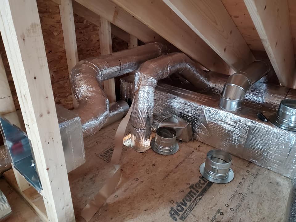There are a lot of pipes in the attic of a house.