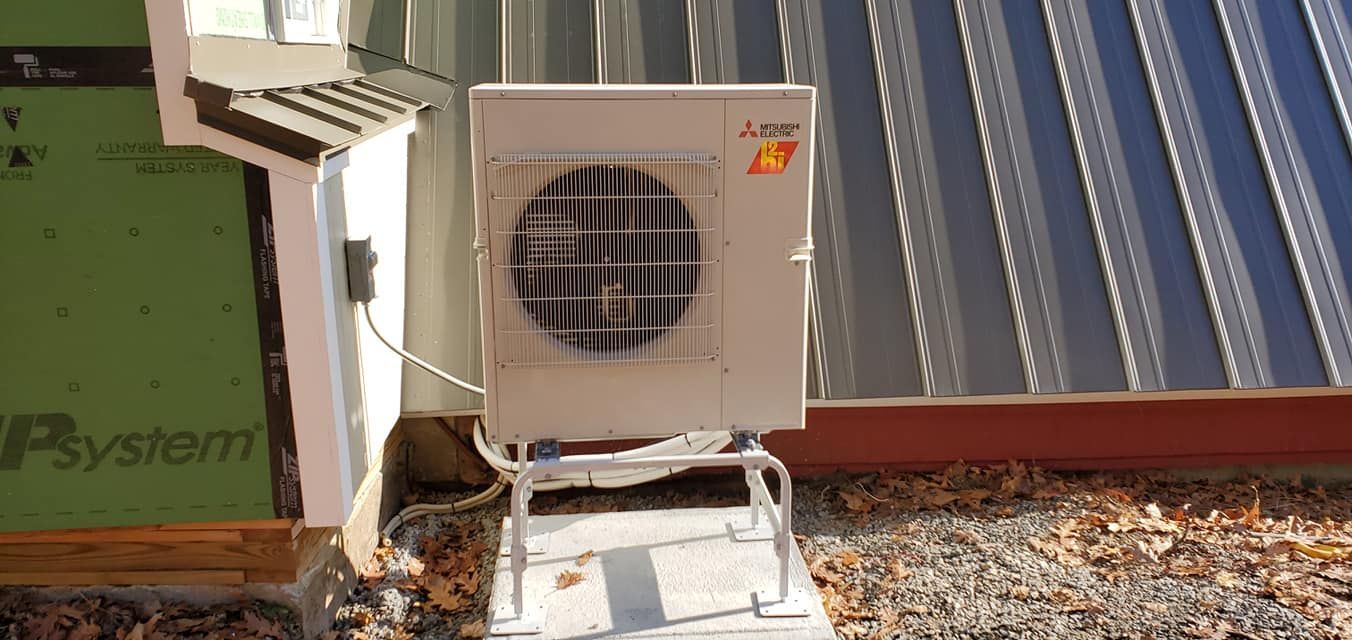A large air conditioner is sitting outside of a building.
