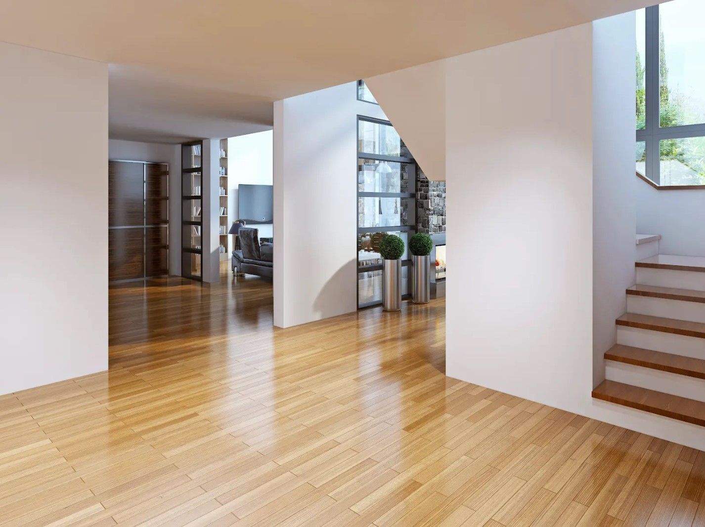 An empty room with hardwood floors and stairs leading up to the second floor.