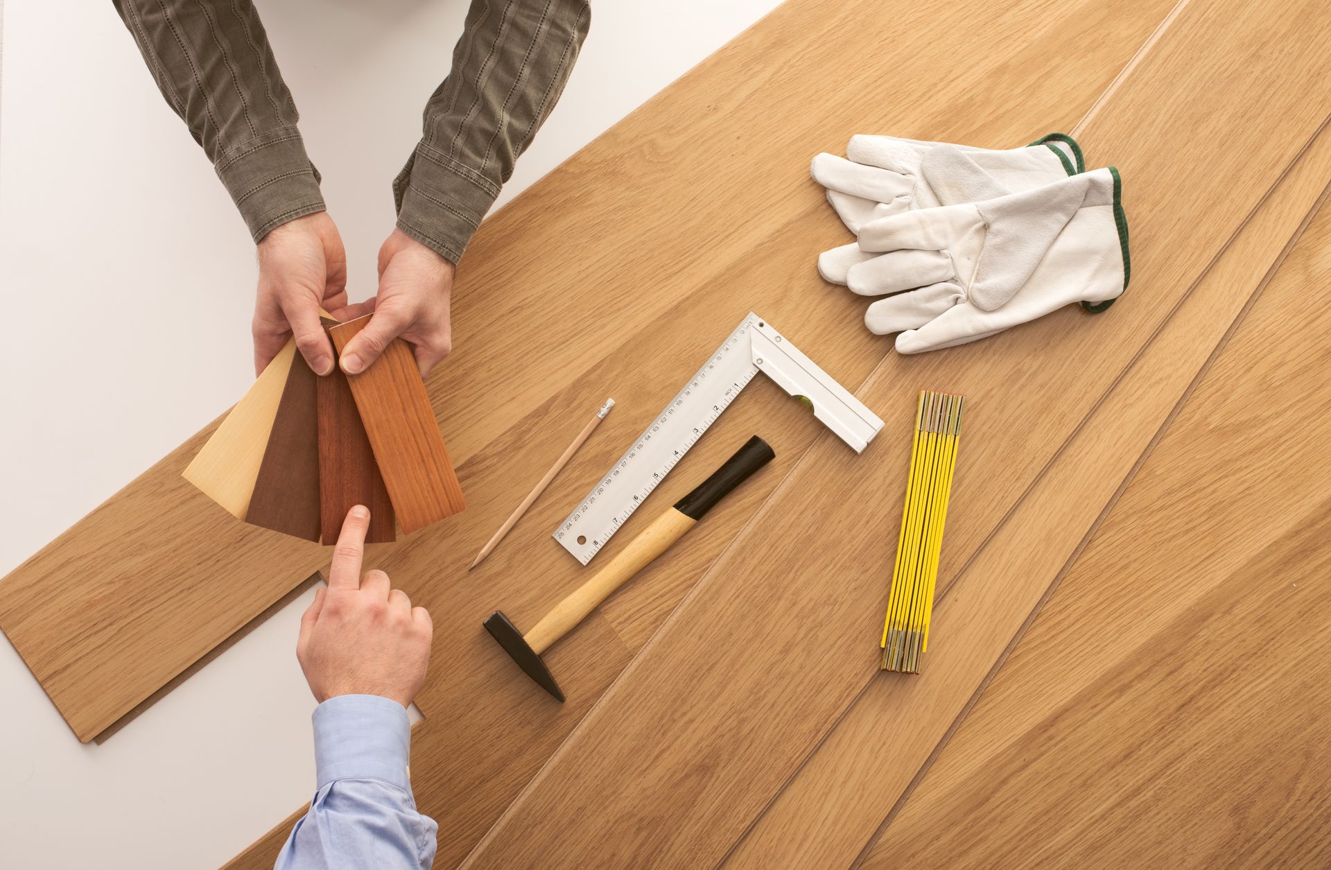 Two people are working on a wooden floor.