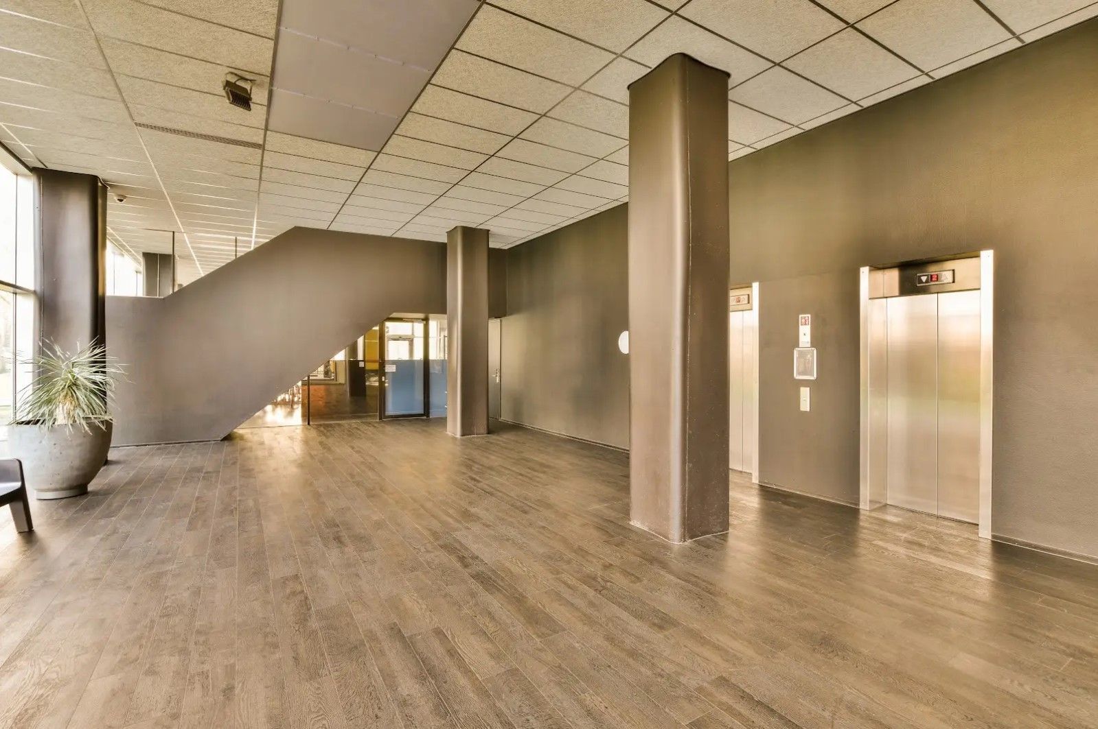 A large empty lobby with elevators and stairs.