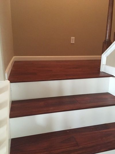 A staircase with wooden steps and white railing in a house.