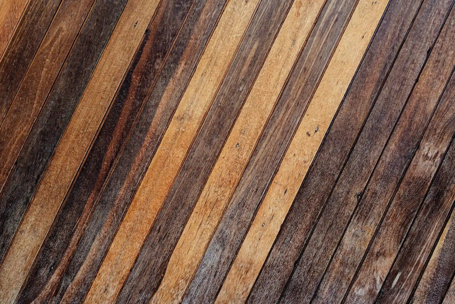 A close up of a wooden surface with a diagonal striped pattern.