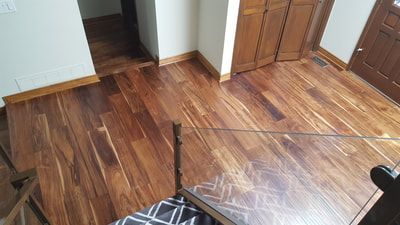 A room with hardwood floors and a glass table.