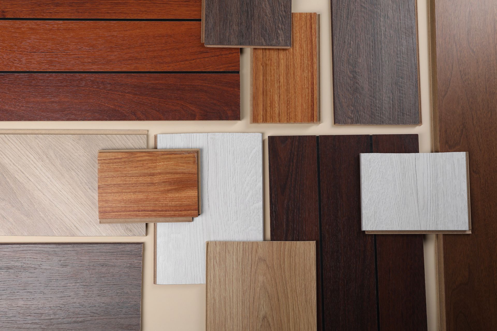 Assorted wood and tile samples arranged in a grid of warm browns, grays, and white finishes