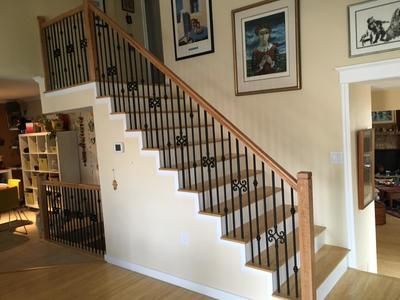 A wooden staircase with a metal railing in a living room.