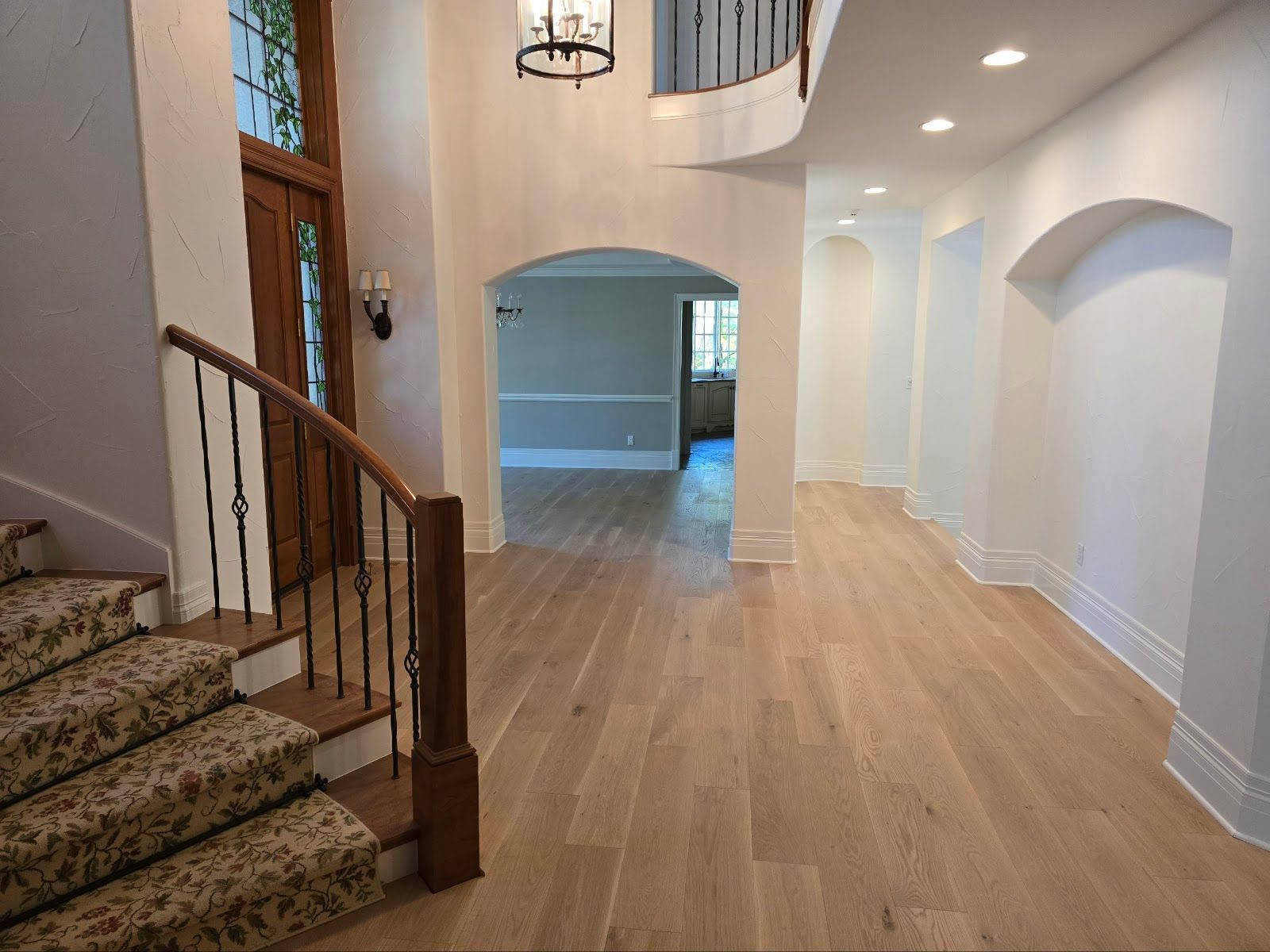 There is a staircase in the middle of the hallway leading up to the second floor.