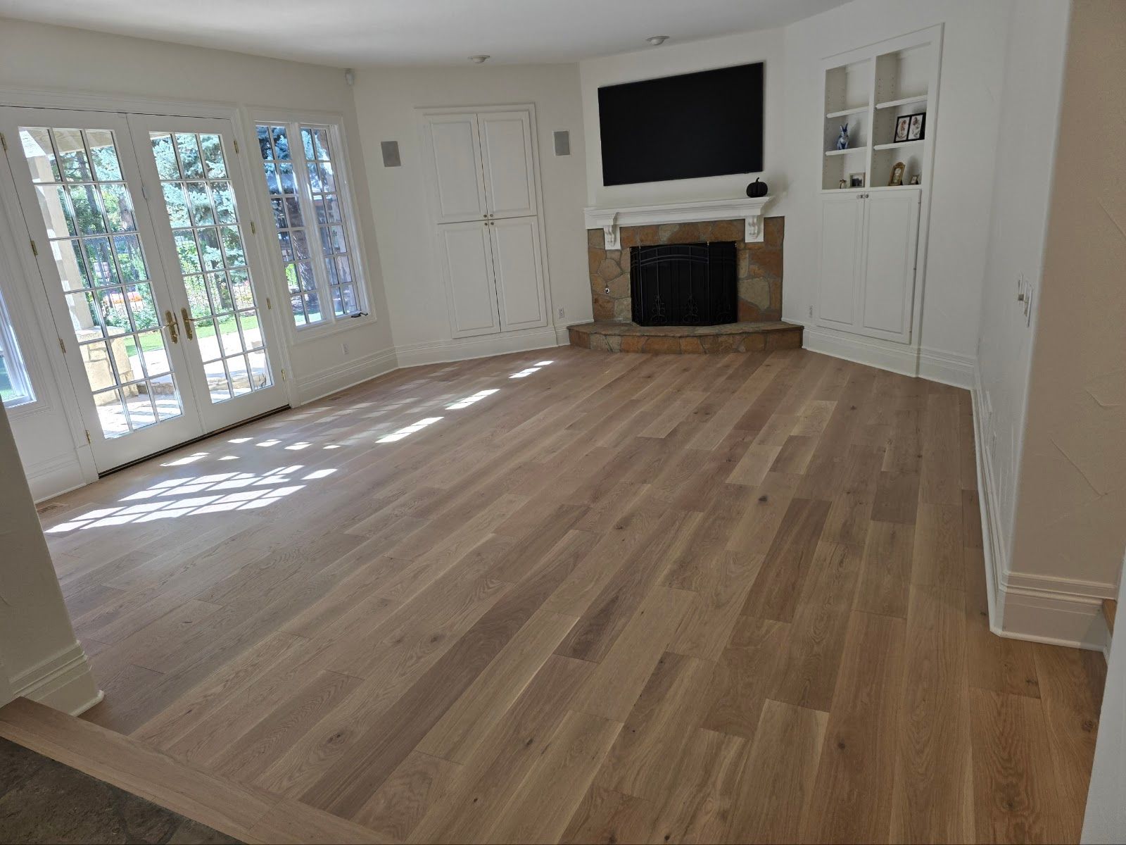A living room with hardwood floors and a fireplace.