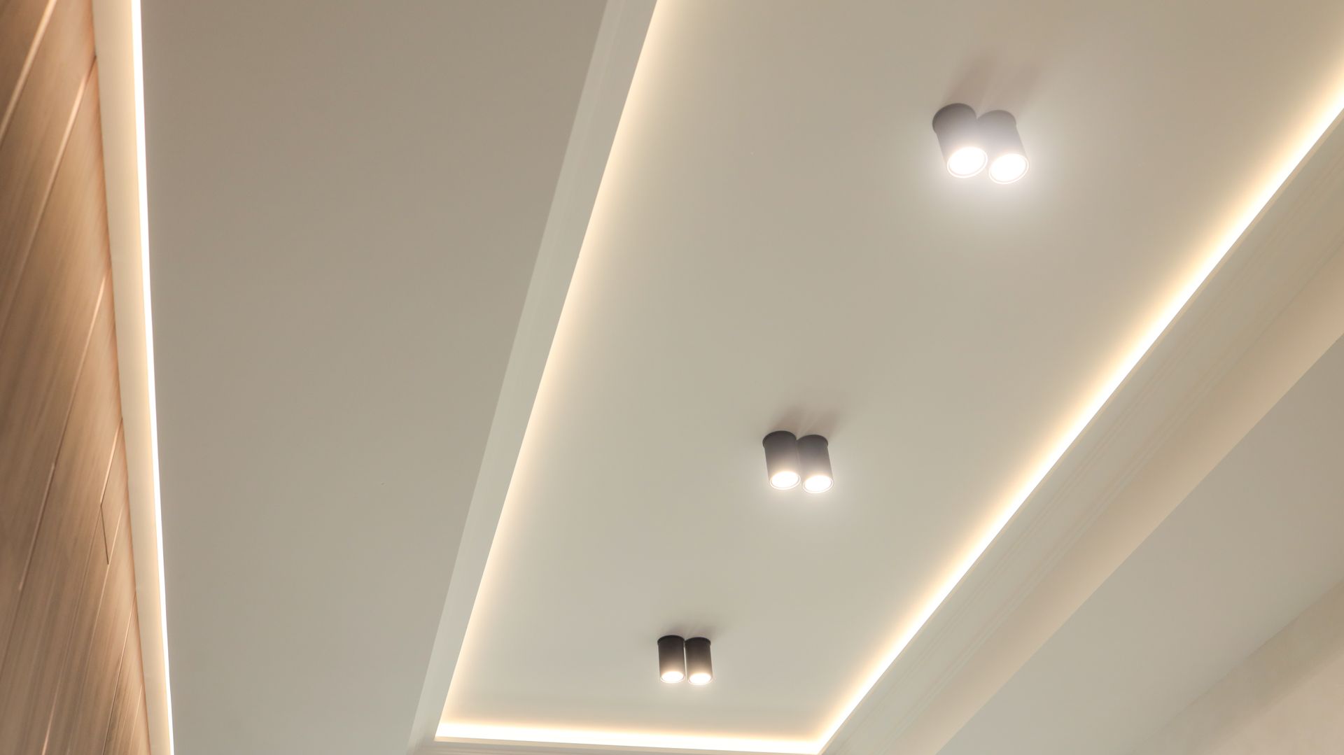 White ceiling with recessed lighting and a strip light.
