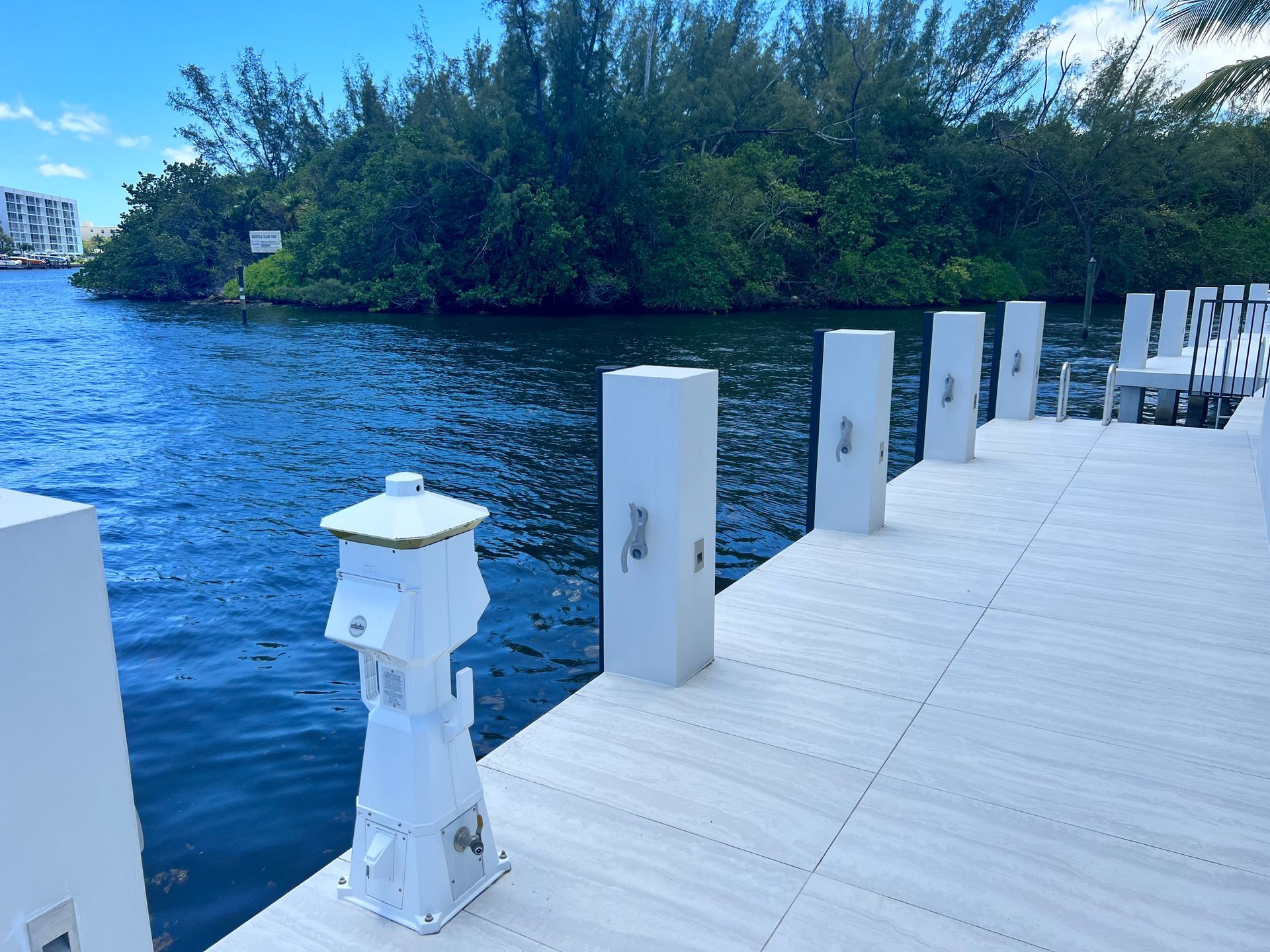 Electrician installing an outlet with tools, wires, and gloves on a white wall.