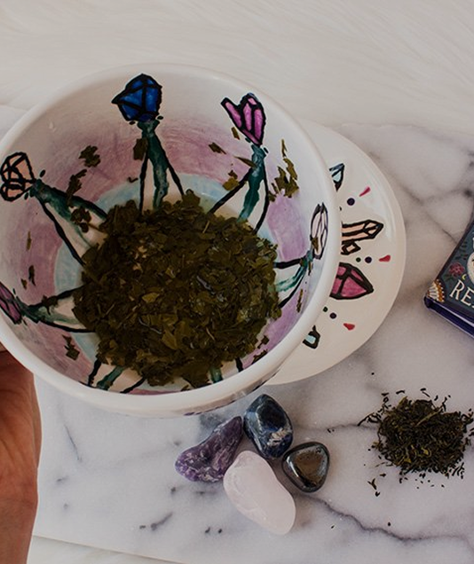 A person is holding a cup with a drawing of flowers on it