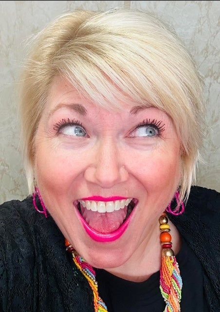 A woman wearing a black shirt and pink earrings is making a funny face