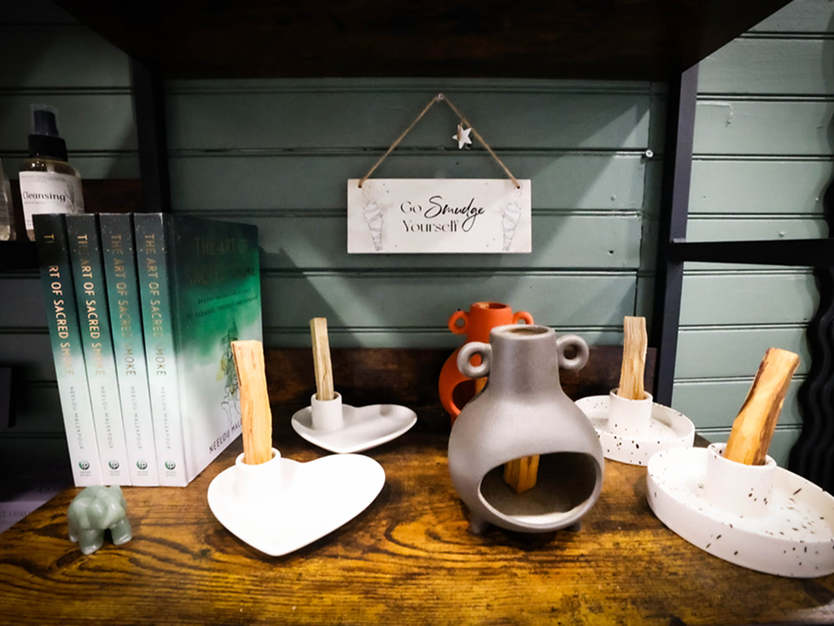 A wooden table topped with a variety of vases and candles.