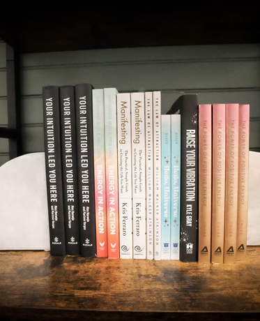 A shelf full of books including one titled pause your vibration