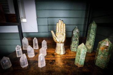 A table topped with crystals and a hand statue.