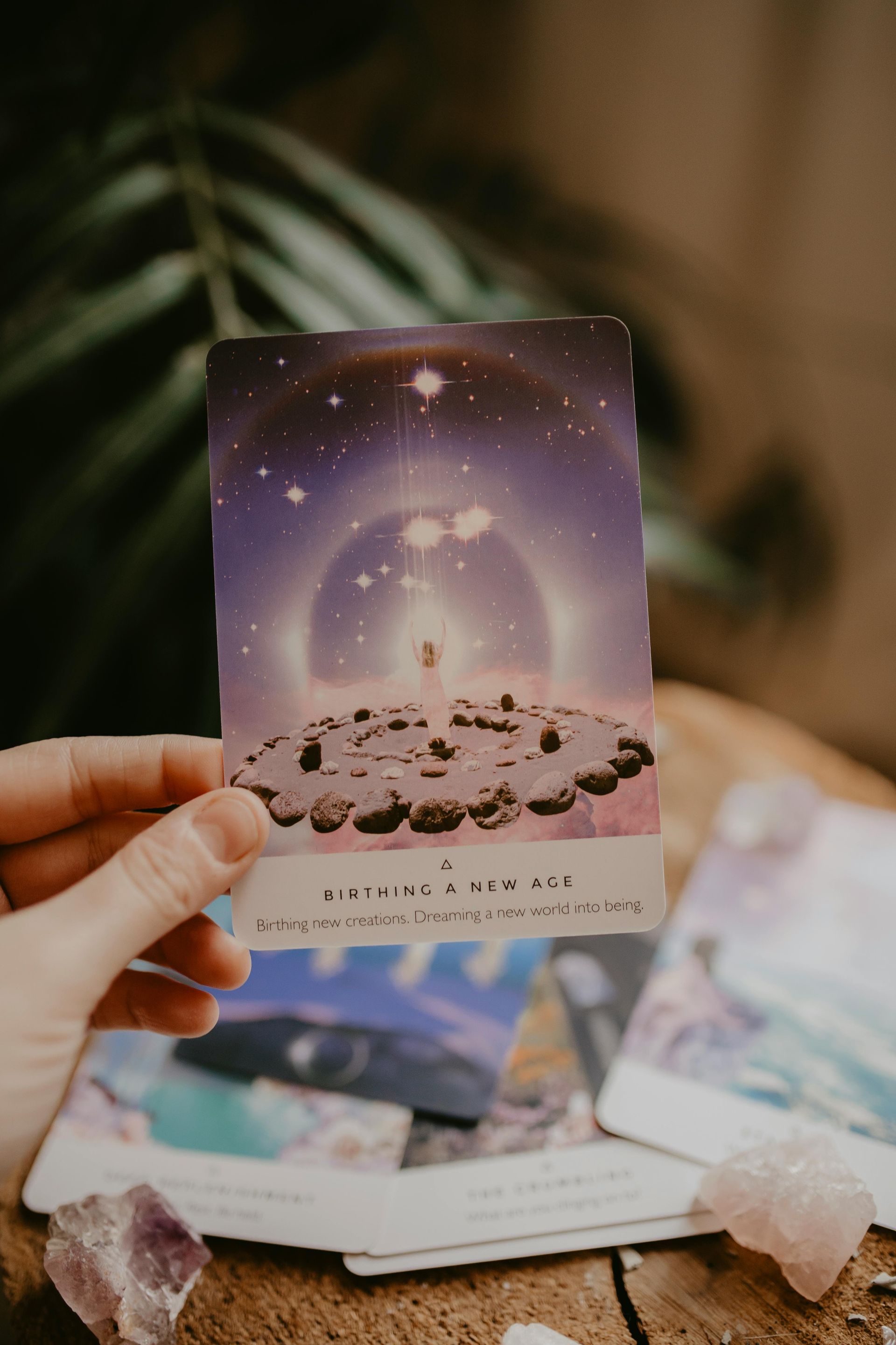 A person is holding a tarot card in their hand.