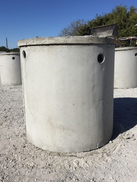 A septic tank is being built in a dirt field