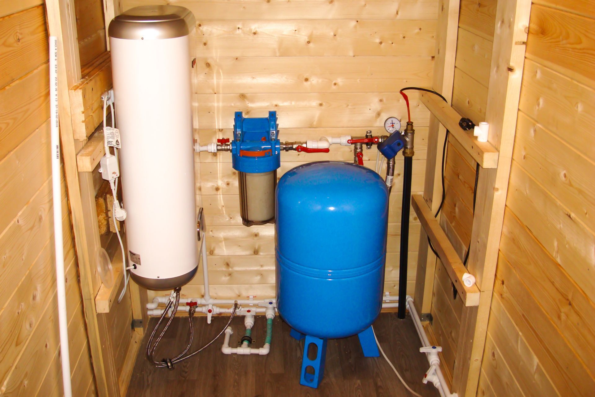 A room with a water heater and a blue tank