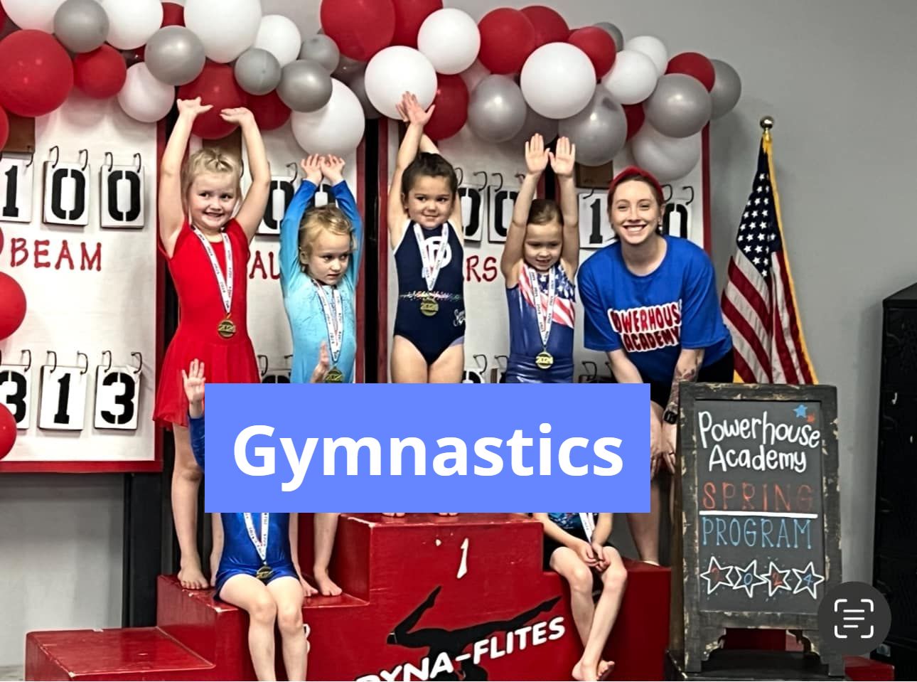 A group of young girls are standing on a podium with a sign that says gymnastics.