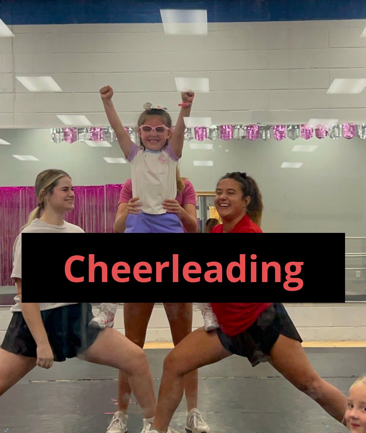 A group of young girls are cheerleading in a gym.
