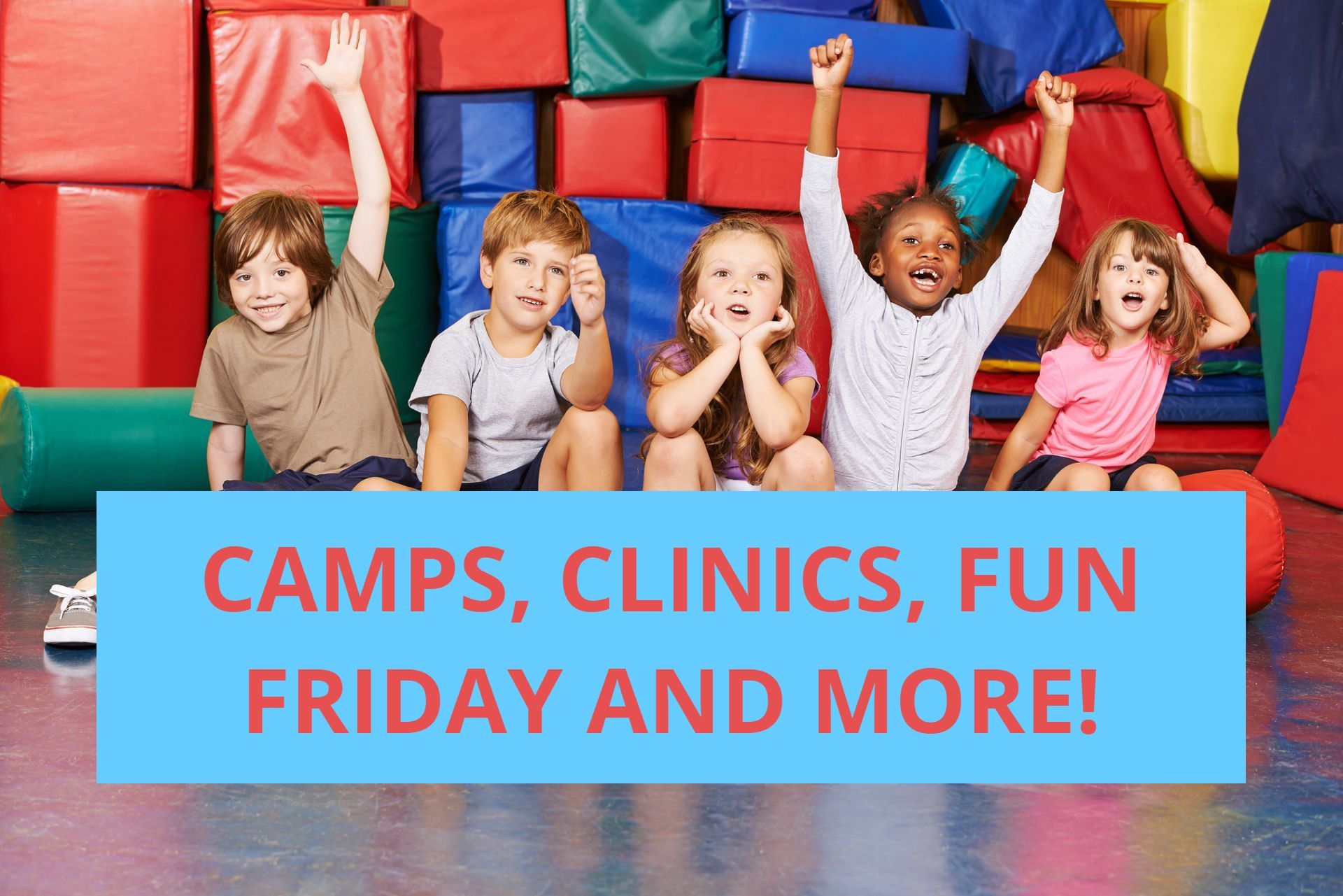 A group of children are sitting on the floor with their hands in the air.