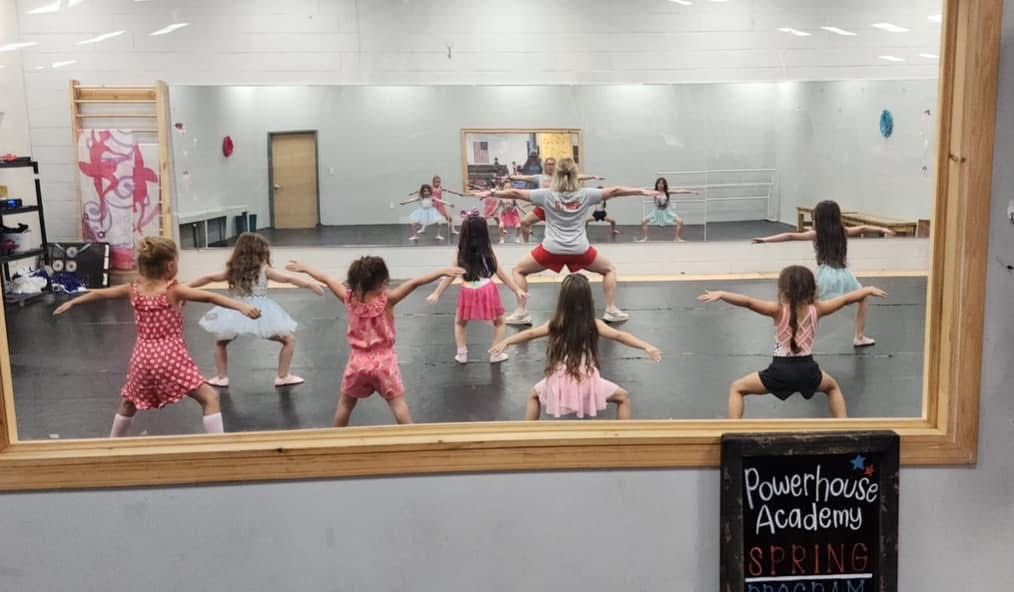 A group of young girls are dancing in a dance studio.