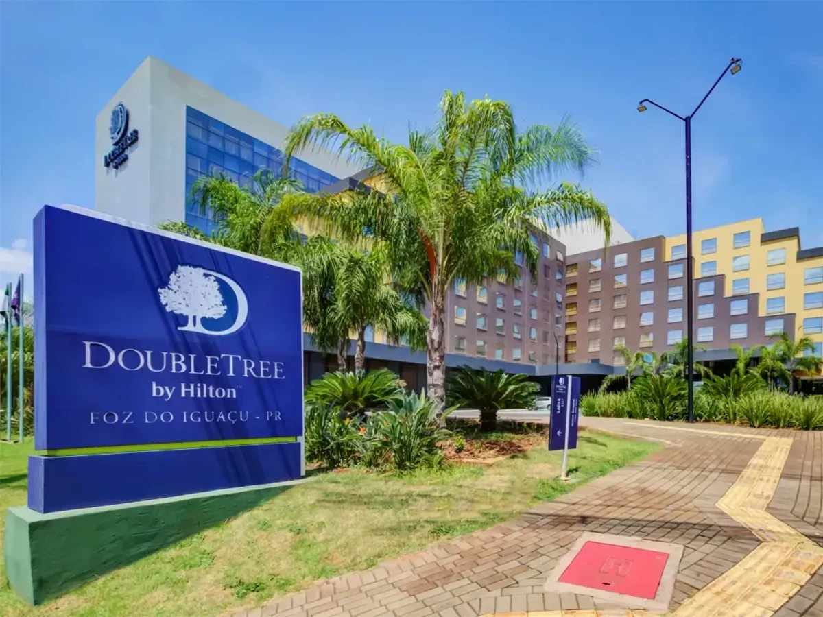 Edifício e placa do hotel DoubleTree by Hilton em um dia ensolarado.