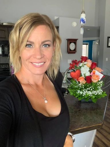 A little girl is carrying a cardboard box in front of her parents.