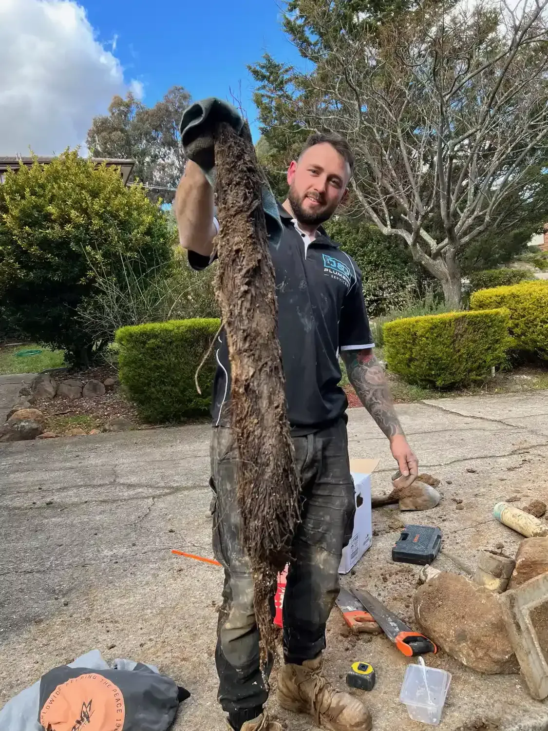 A man is holding a large piece of wood in his hands.