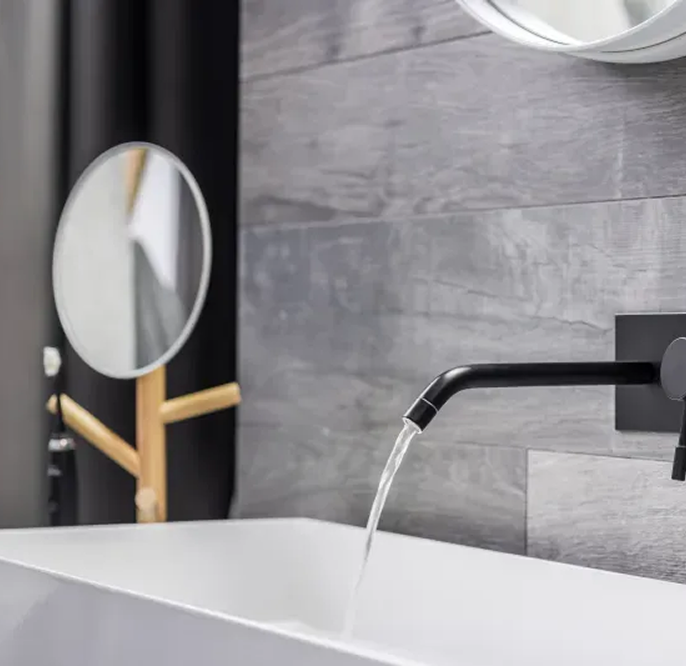 A bathroom sink with a black faucet and a mirror.