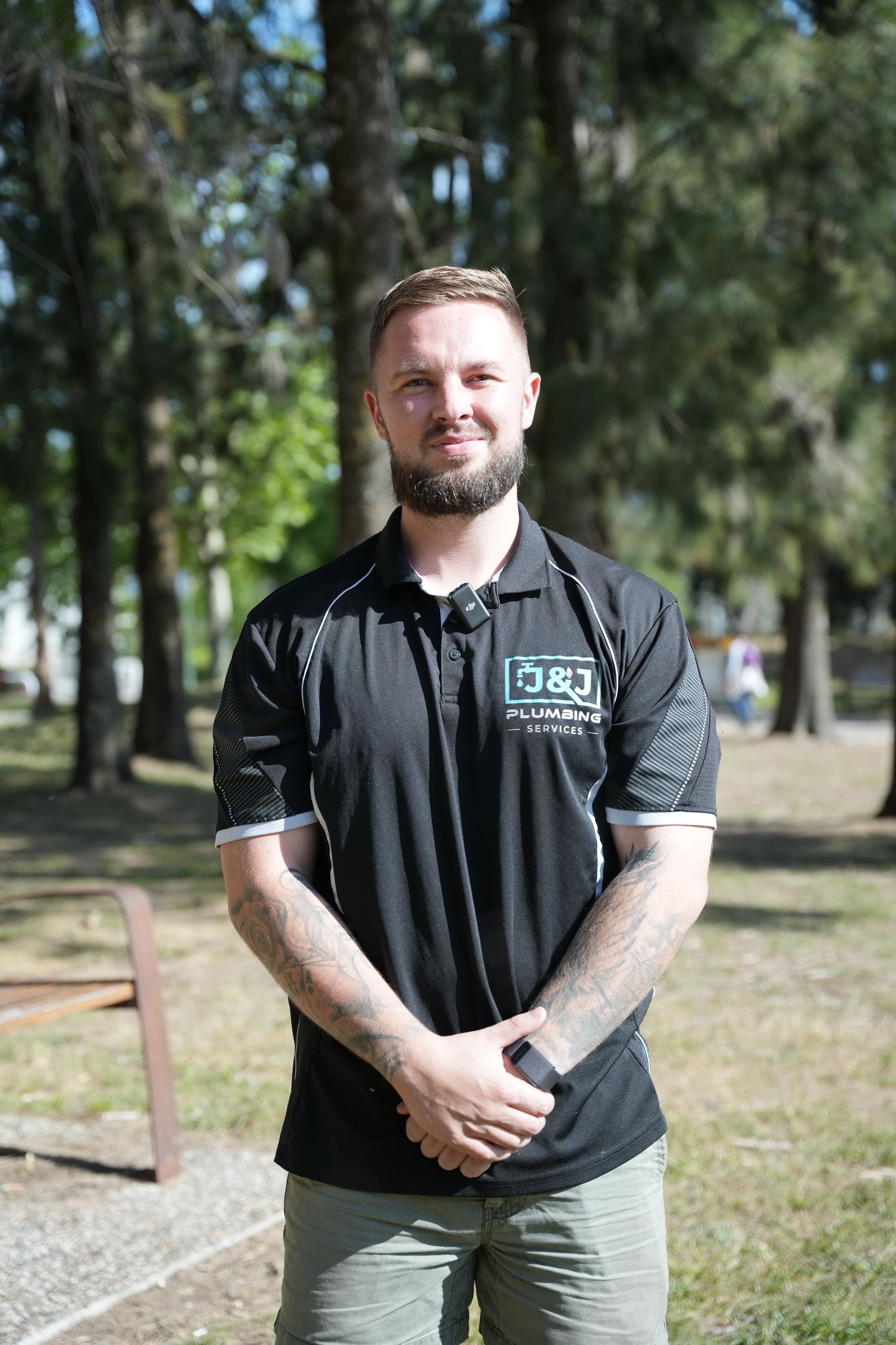 A man is kneeling down next to a drain pipe.