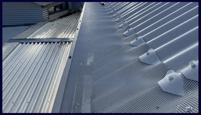 close-up of a metal gutter with an ember guard installed on a steel roof