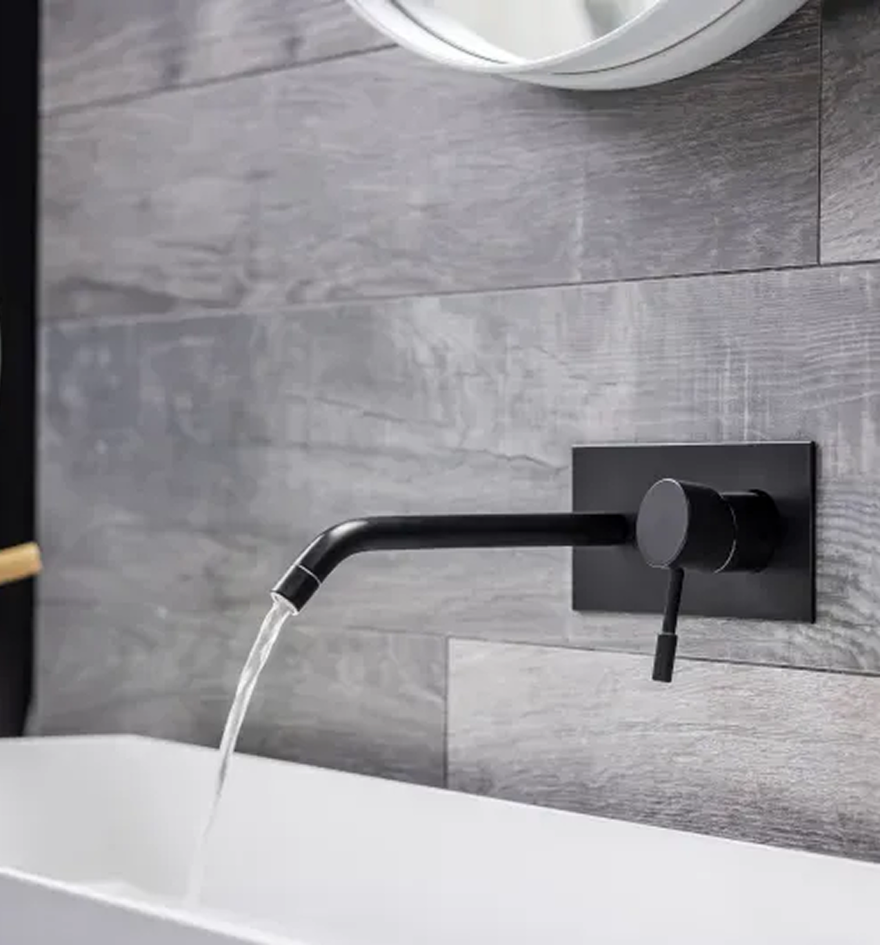A bathroom sink with a black faucet and a mirror.