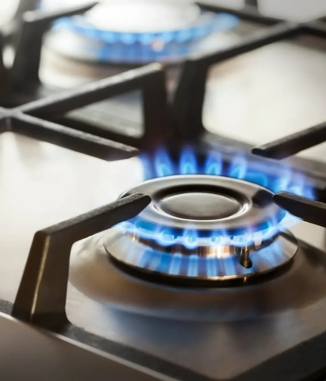 A close up of a gas stove with blue flames