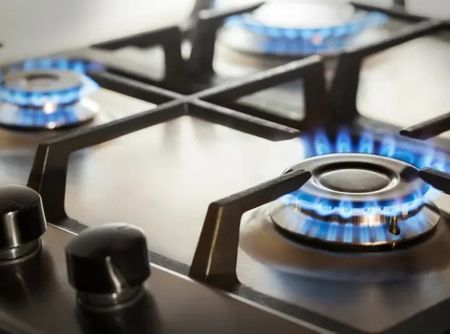 A close up of a gas stove with flames coming out of the burners.