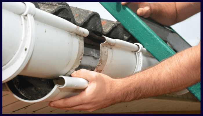 person inspecting and repairing a residential gutter system