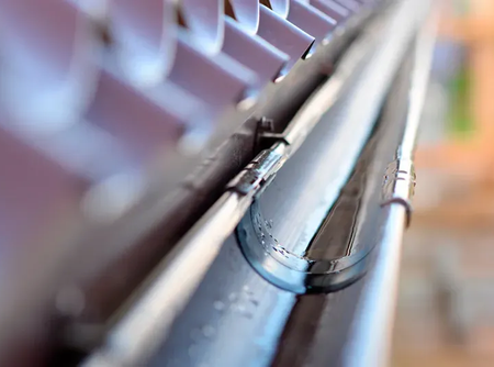 A close up of a metal gutter on a roof.
