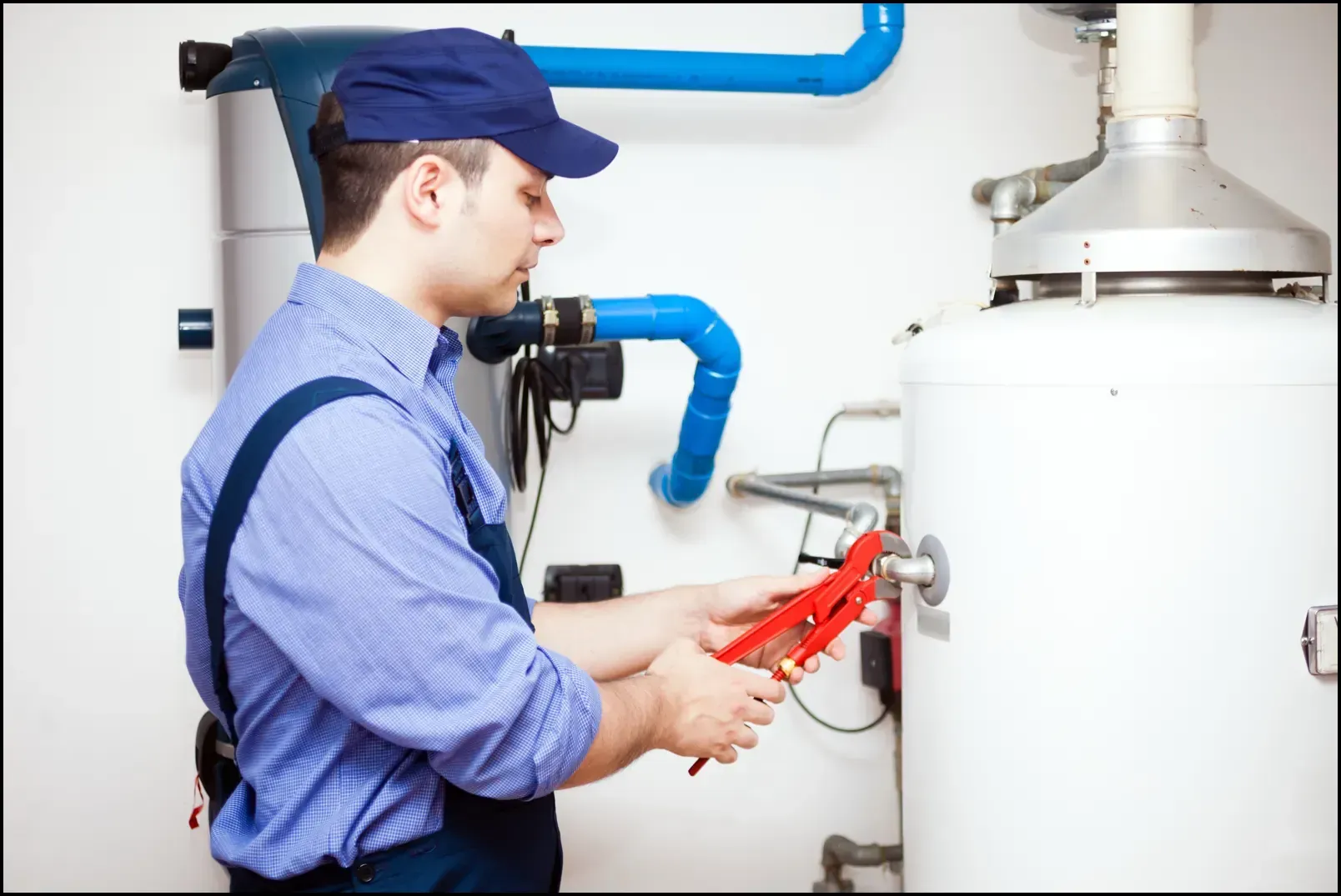 Licensed plumber performing maintenance on a residential hot water system